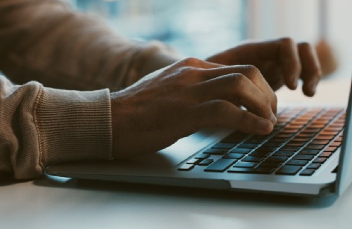 Handen op toetsenbord laptop